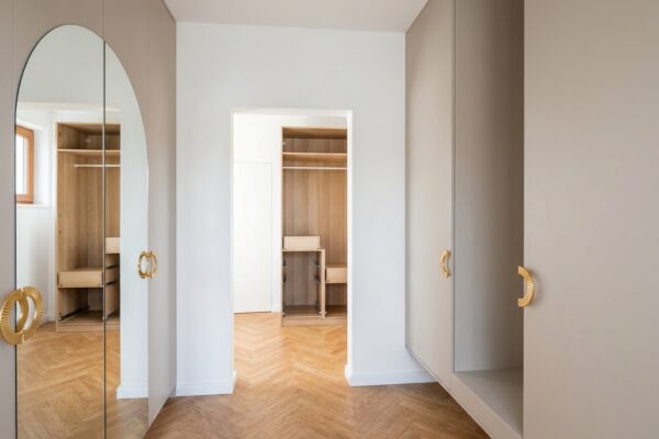 Nowoczesny przedpokój z szafą wiszącą i szafą na wymiar z lustrem łukowym